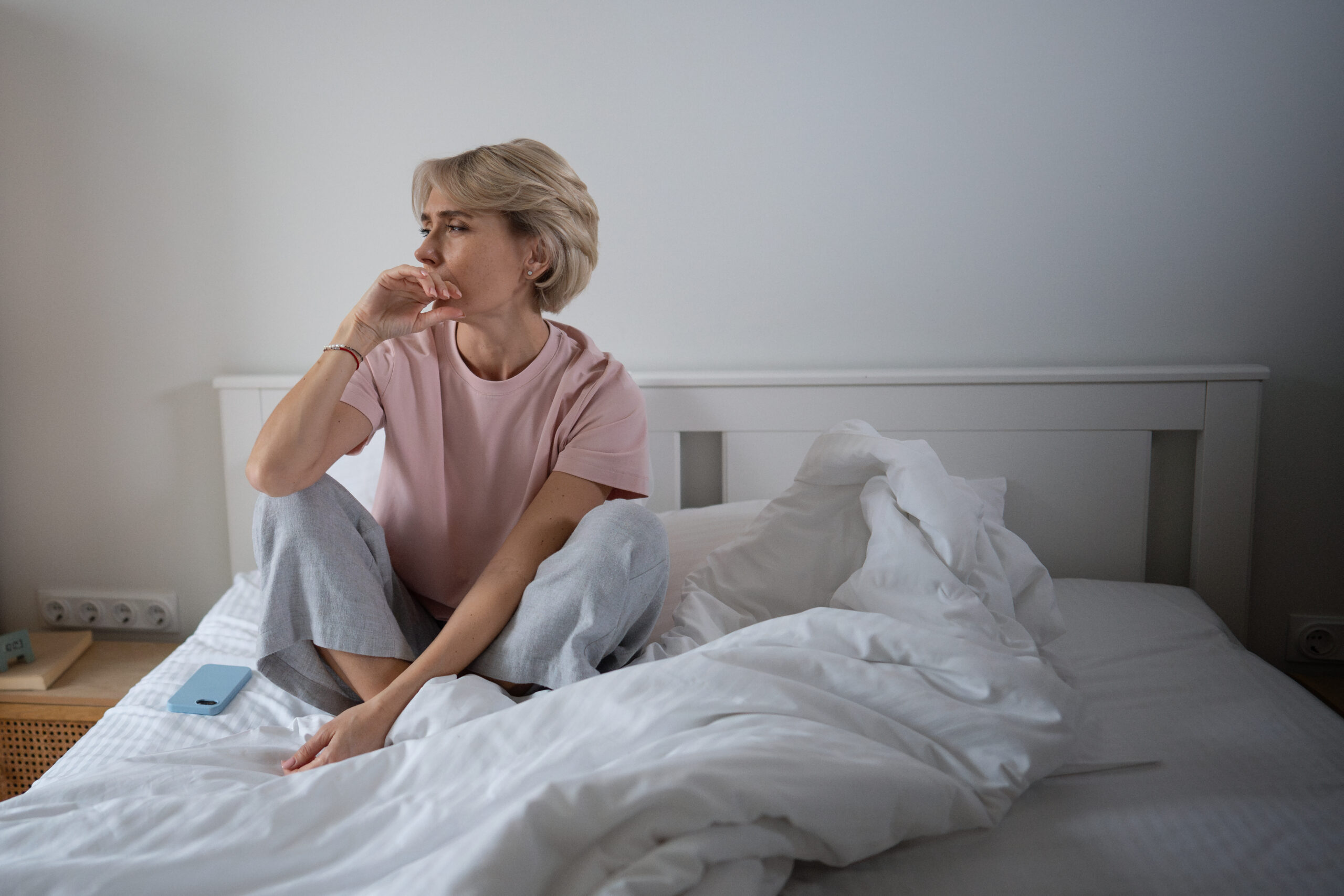 Midlife woman tired in bed, illustrating how hormones affect sleep