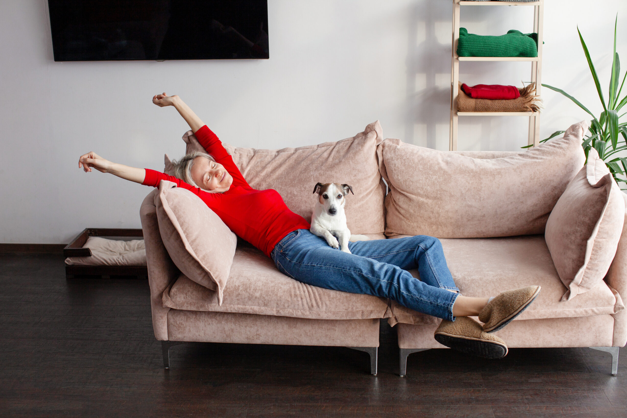 Woman in her 40s stretching at home, supporting recovery over aggressive dieting