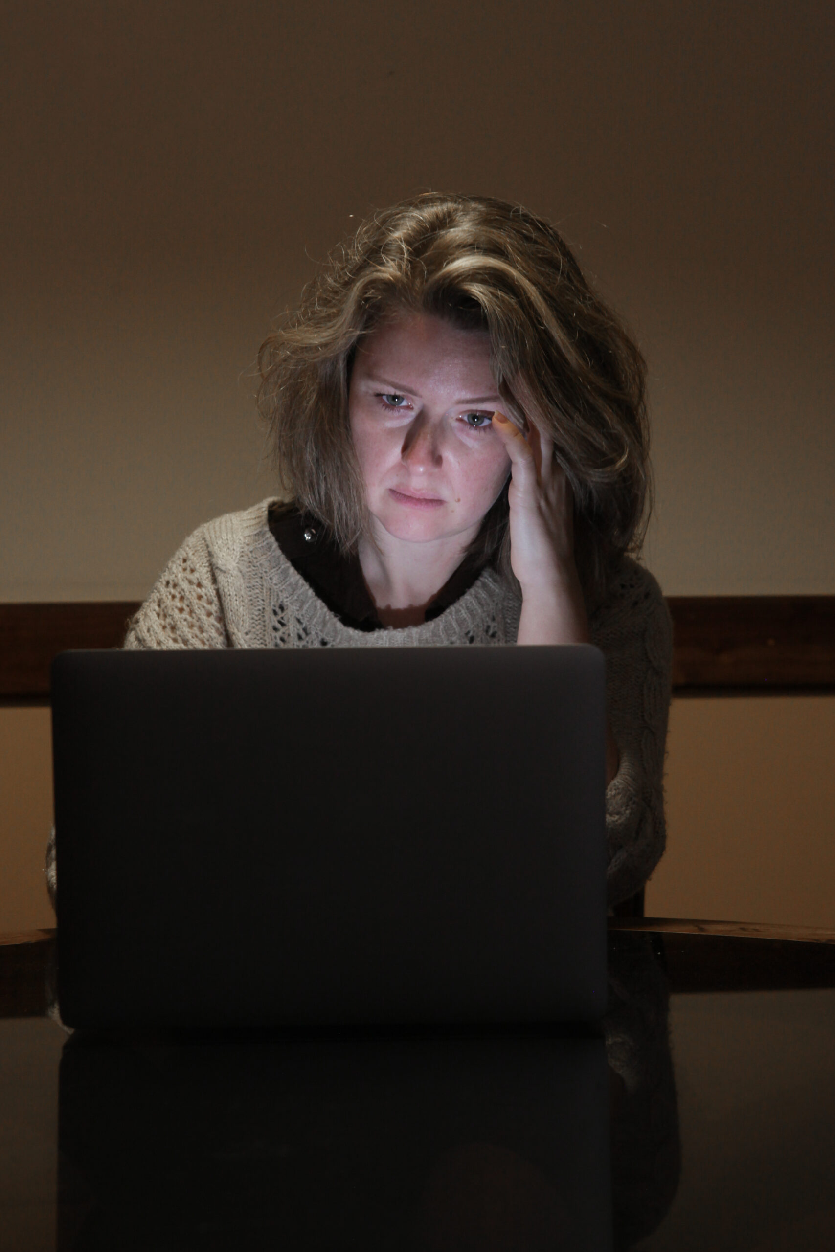 Middle-aged woman working late at night, carrying a heavy daily stress load
